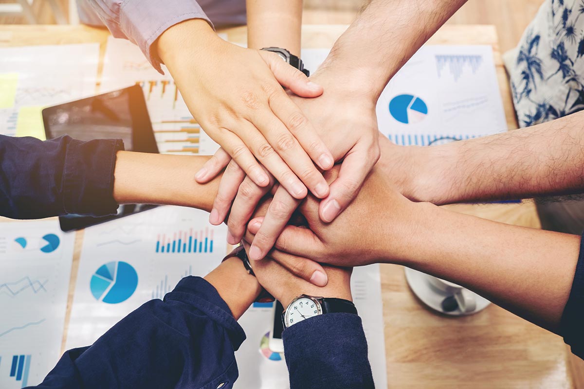 Group of people bringing their hands together